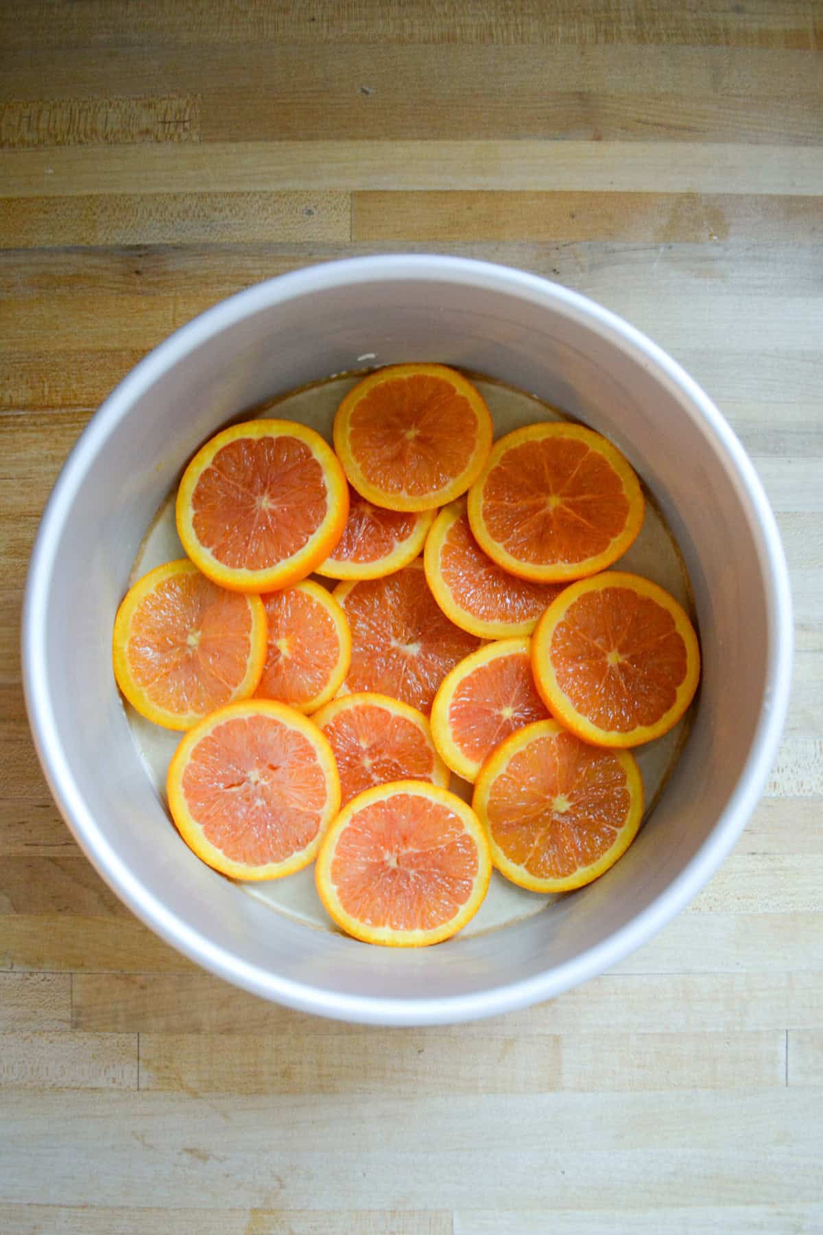 Candied orange slices at the bottom of a round pan.