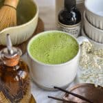 Vanilla Matcha Latte in a mug on a white cloth.