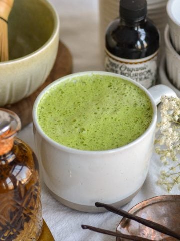 Vanilla Matcha Latte in a mug on a white cloth.