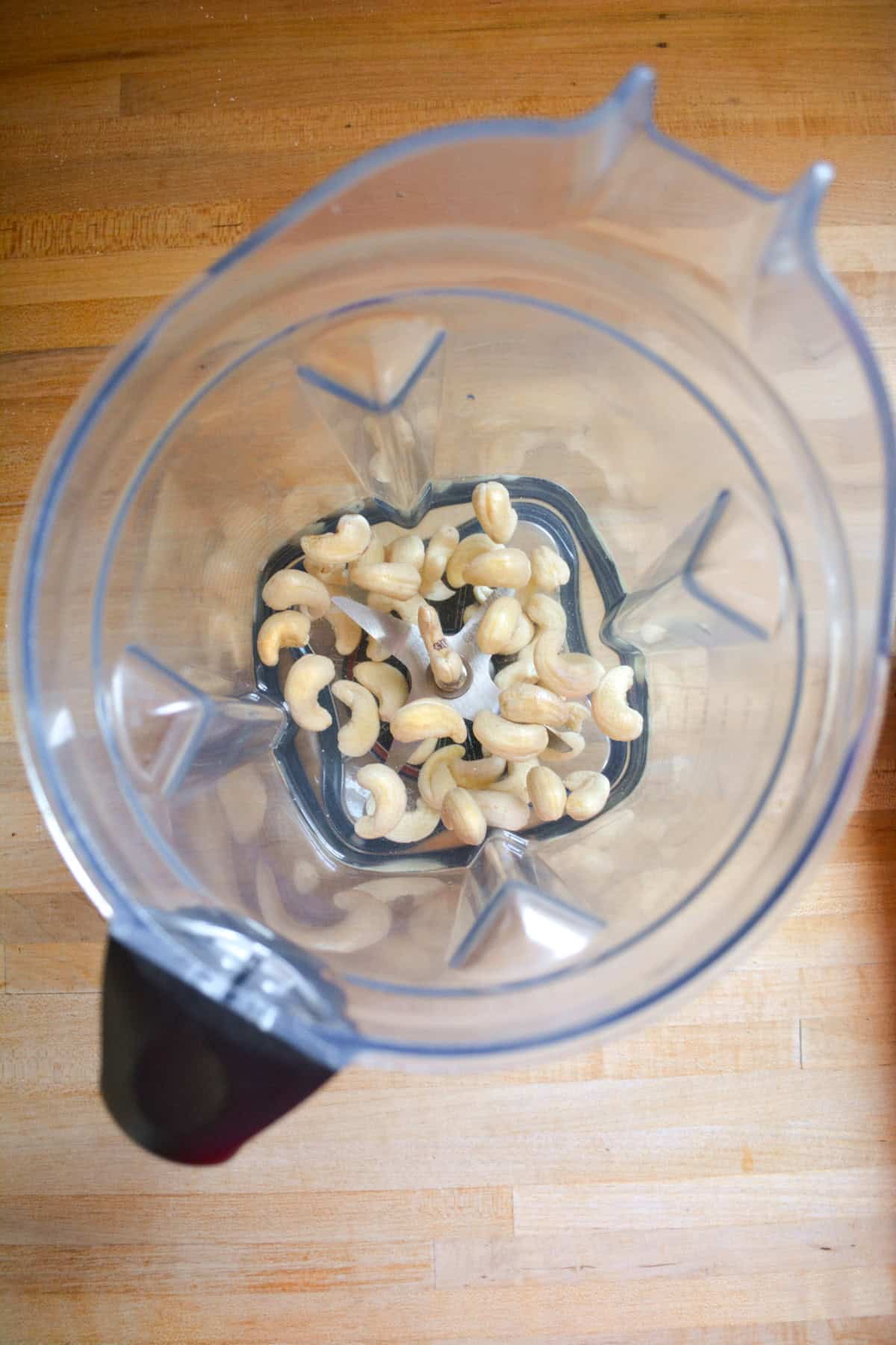Cashews soaking in the pitcher of a blender.