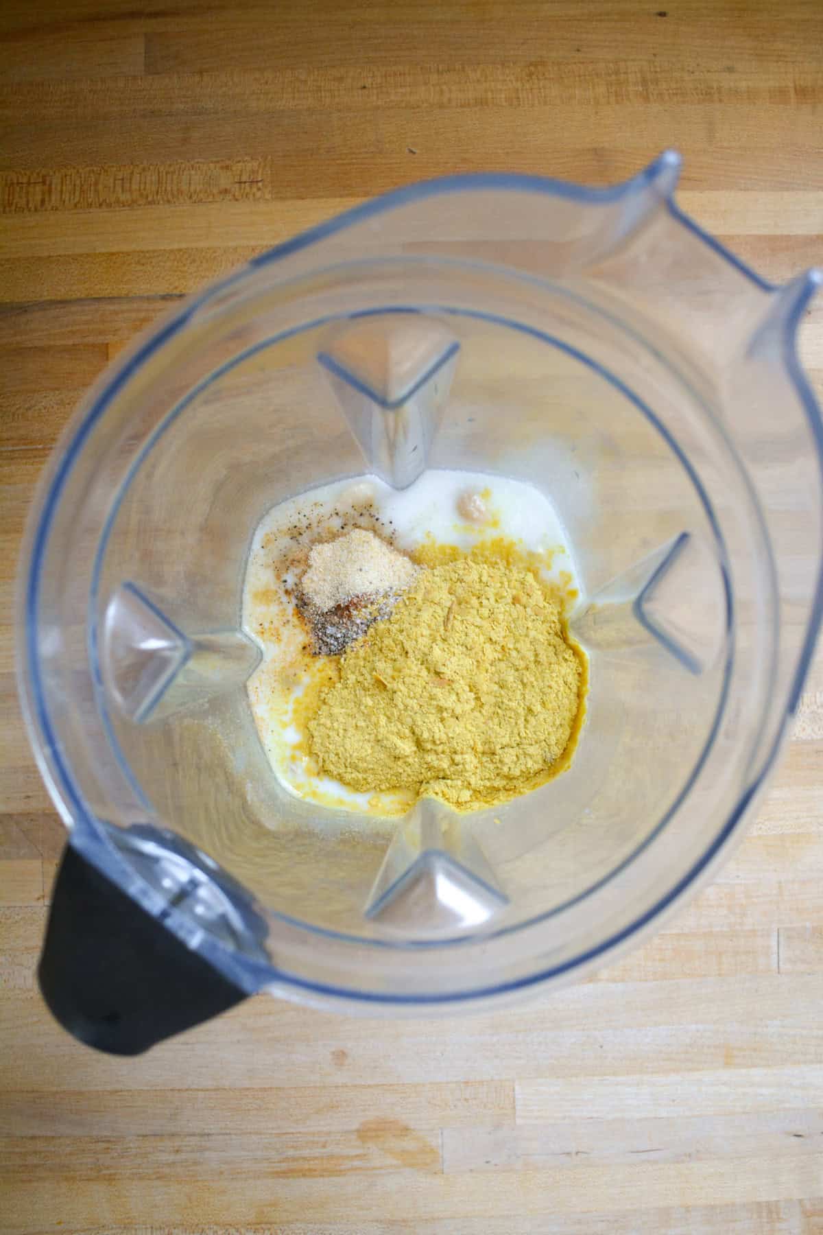 Sauce ingredients added into the pitcher of a blender.