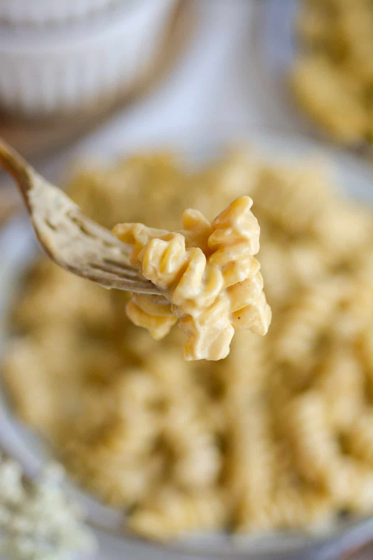 A fork with a bite of Vegan Cashew Mac and Cheese on it.
