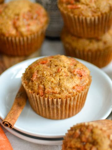 Vegan Carrot Muffin on a small plate with a cinnamon stick.