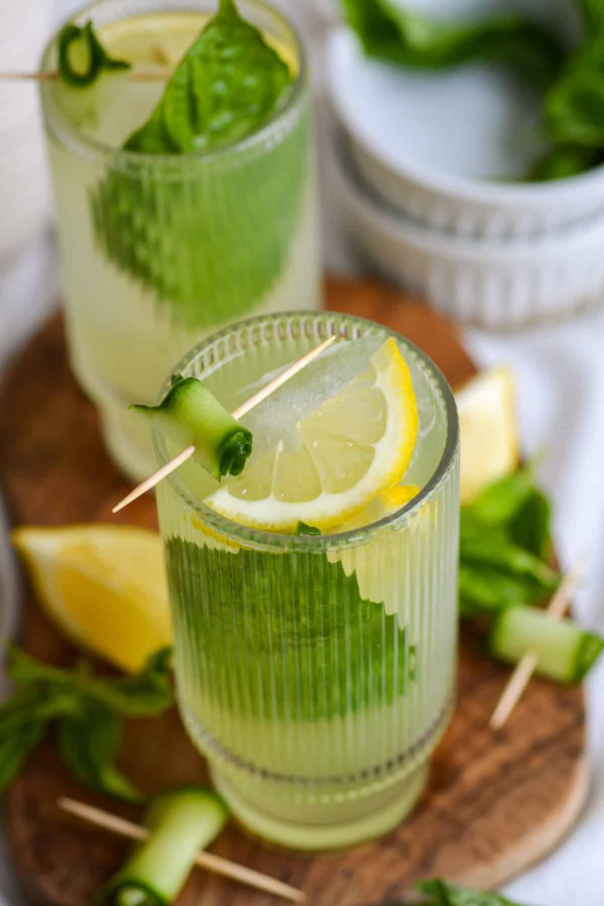 Cucumber Basil Mocktail in a tall glass garnished with a lemon slice and spiral of cucumber.
