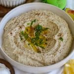 Baba Ganoush in a bowl topped with olive oil and chipped parsley.