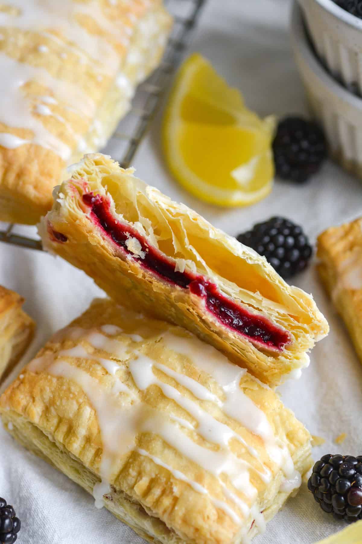 A Vegan Blackberry Hand Pie with puff pastry cut in half to show the interior.