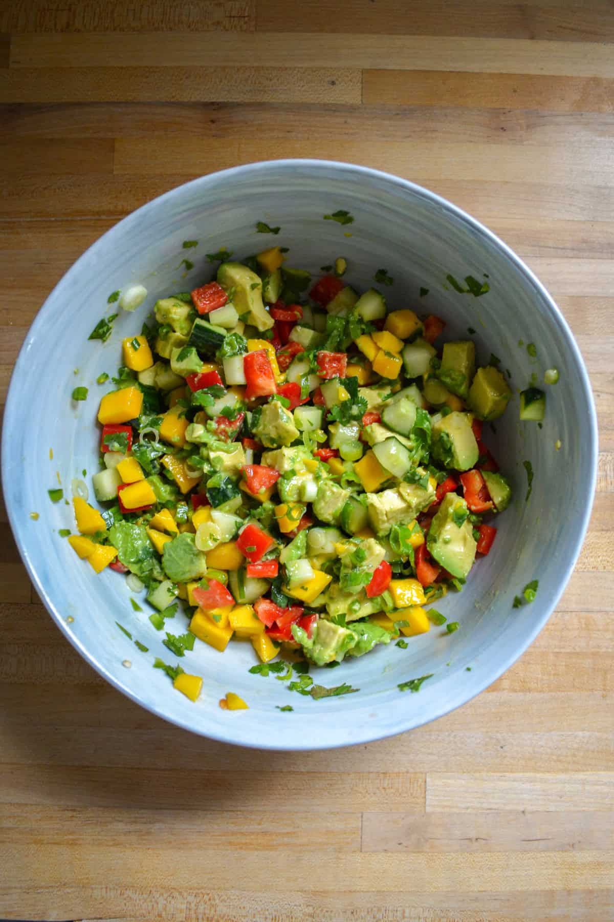 Salad tossed together in a large mixing bowl.