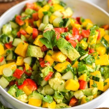 Mango Avocado Cucumber Salad in a bowl topped with cilantro.