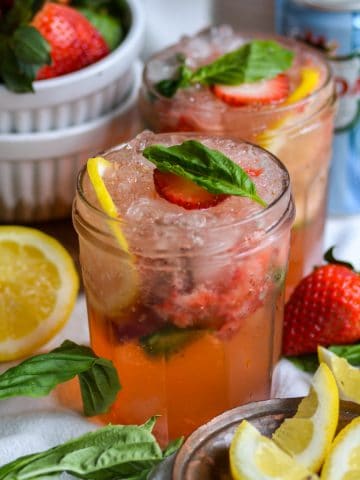 Strawberry Basil Mocktail on a lined cloth with a small bowl of lemon slices in the scene.