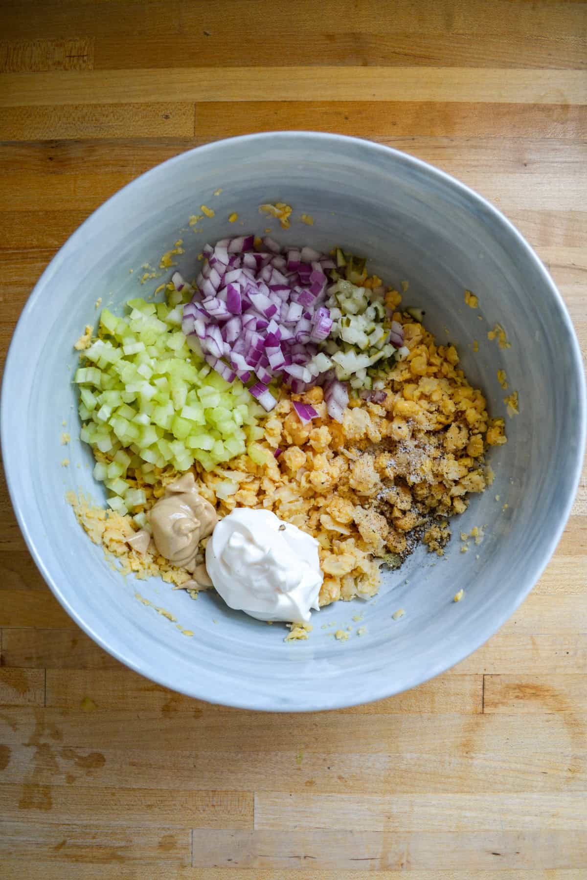 Mayo, mustard, celery, onion and pickles added into the bowl.