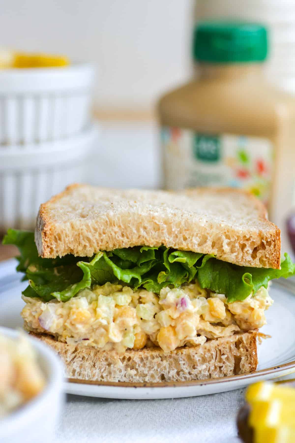 Vegan Chickpea Tuna salad on a sandwich on a small plate.