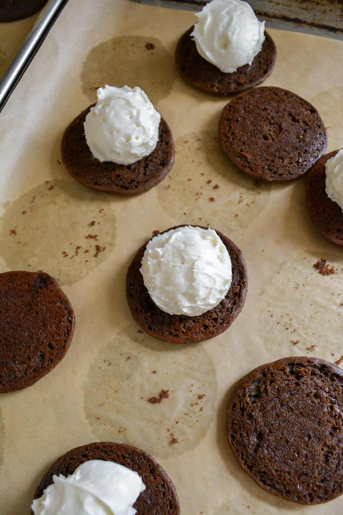 Chocolate cookie topped with a scoop of cream cheese frosting.