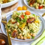 A plate with Orzo Pesto Pasta Salad on it next to a gold fork.