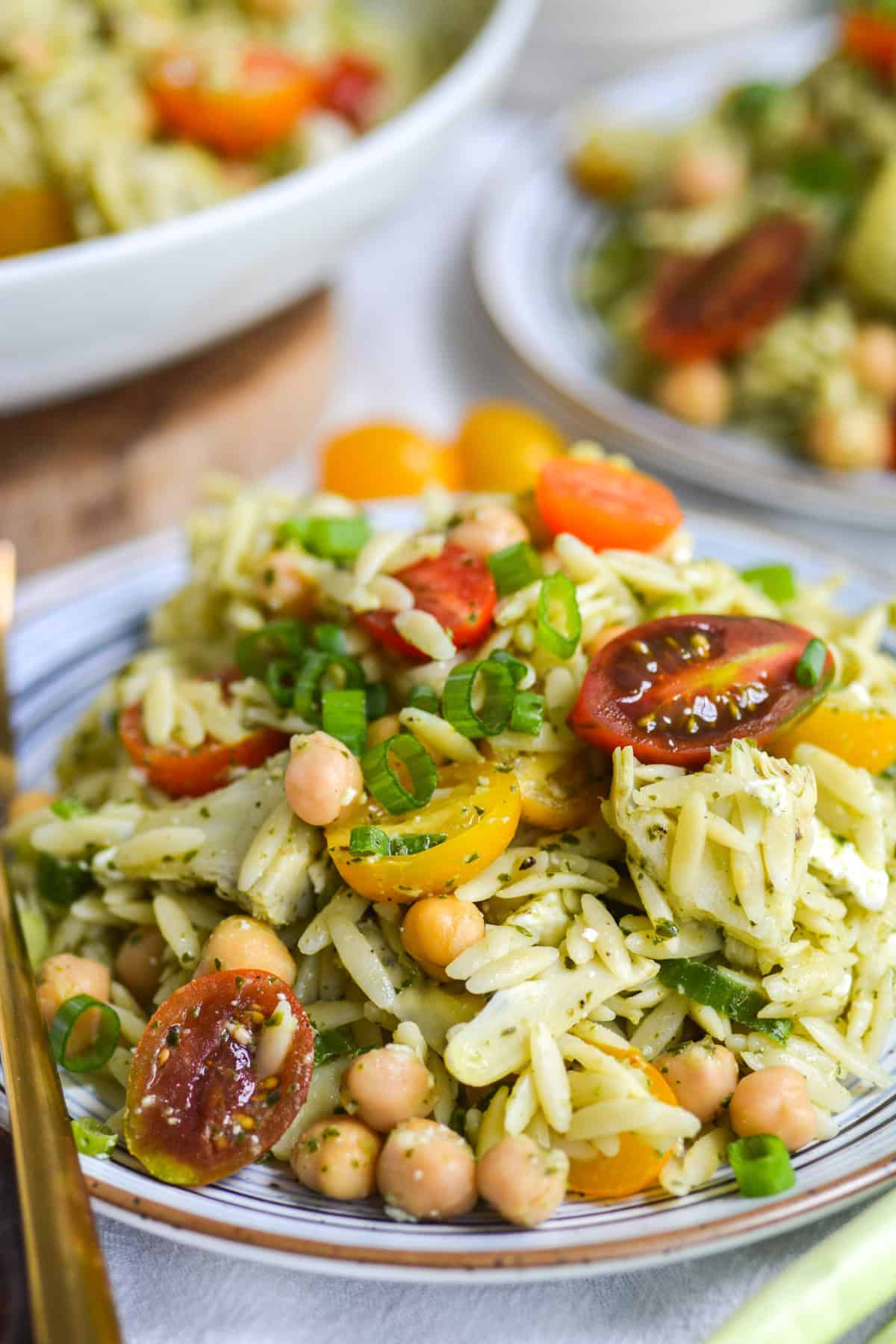 A small plate topped with Orzo Pesto Pasta Salad on it.