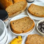 A slice of Vegan Banana Bread on a white plate on a linen coth.
