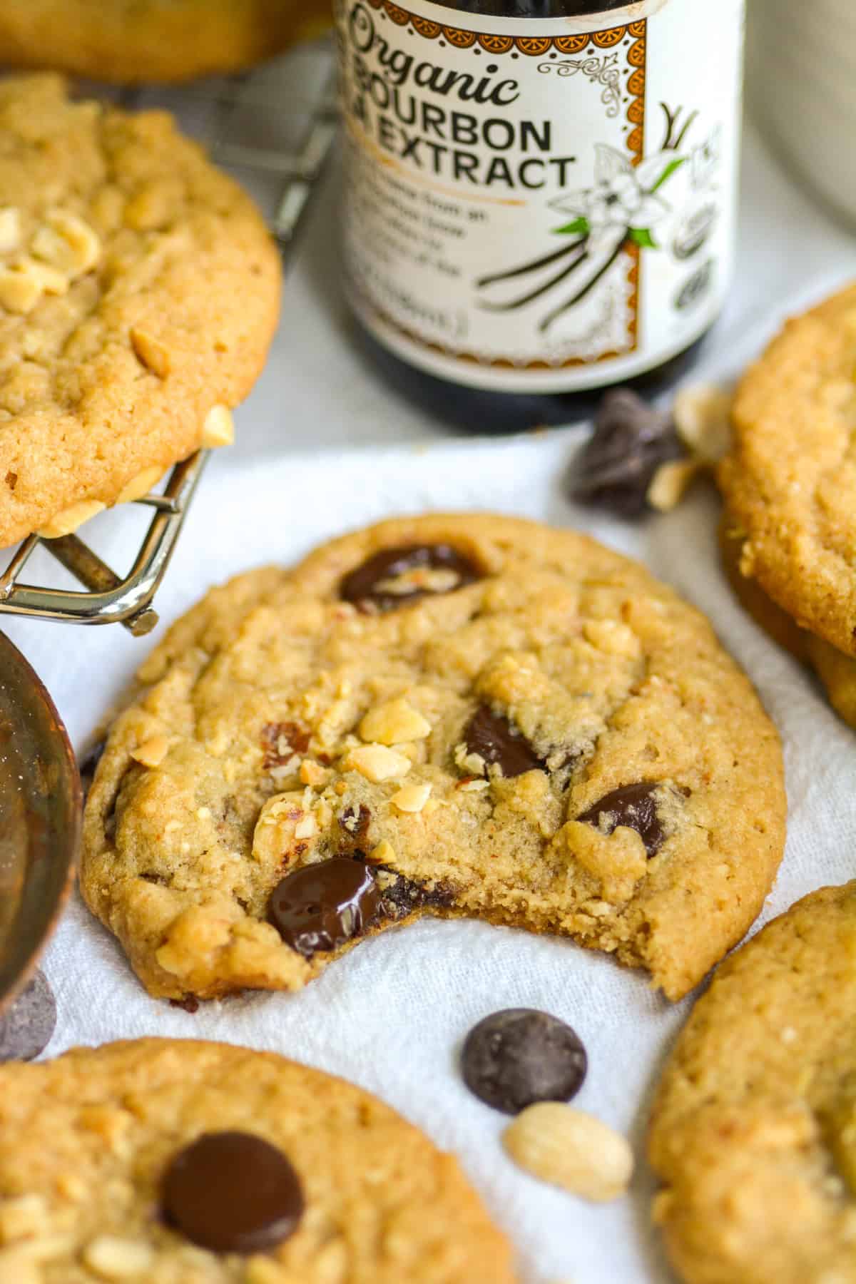 A Vegan Peanut Butter Chocolate Chip Cookie with a bite taken out of it on a linen cloth.