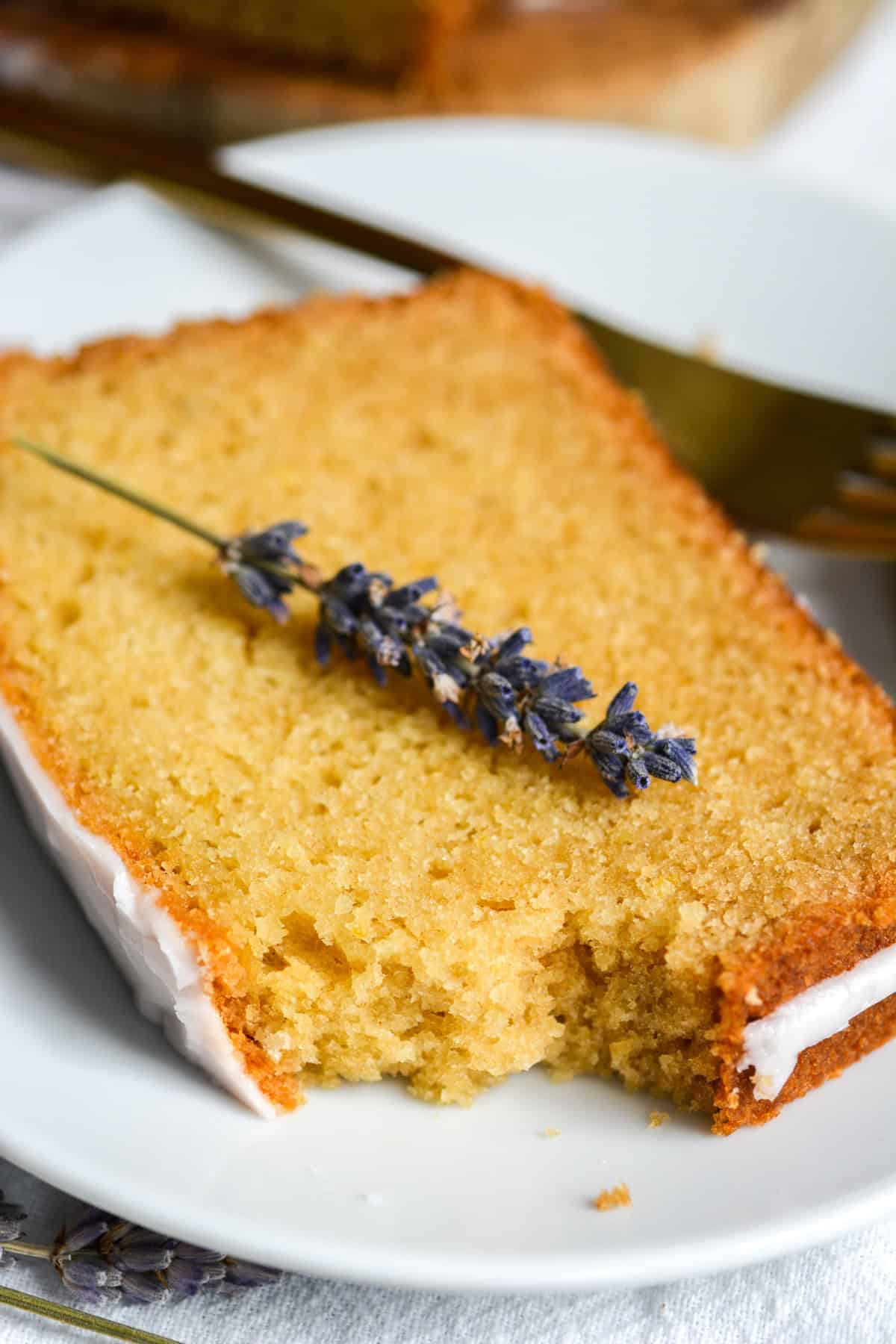 A bite taken out of a slice of lemon lavender cake.