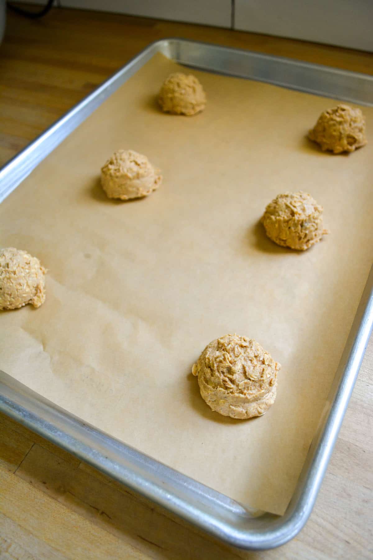 Cookies scooped onto a parchment lined baking sheet.