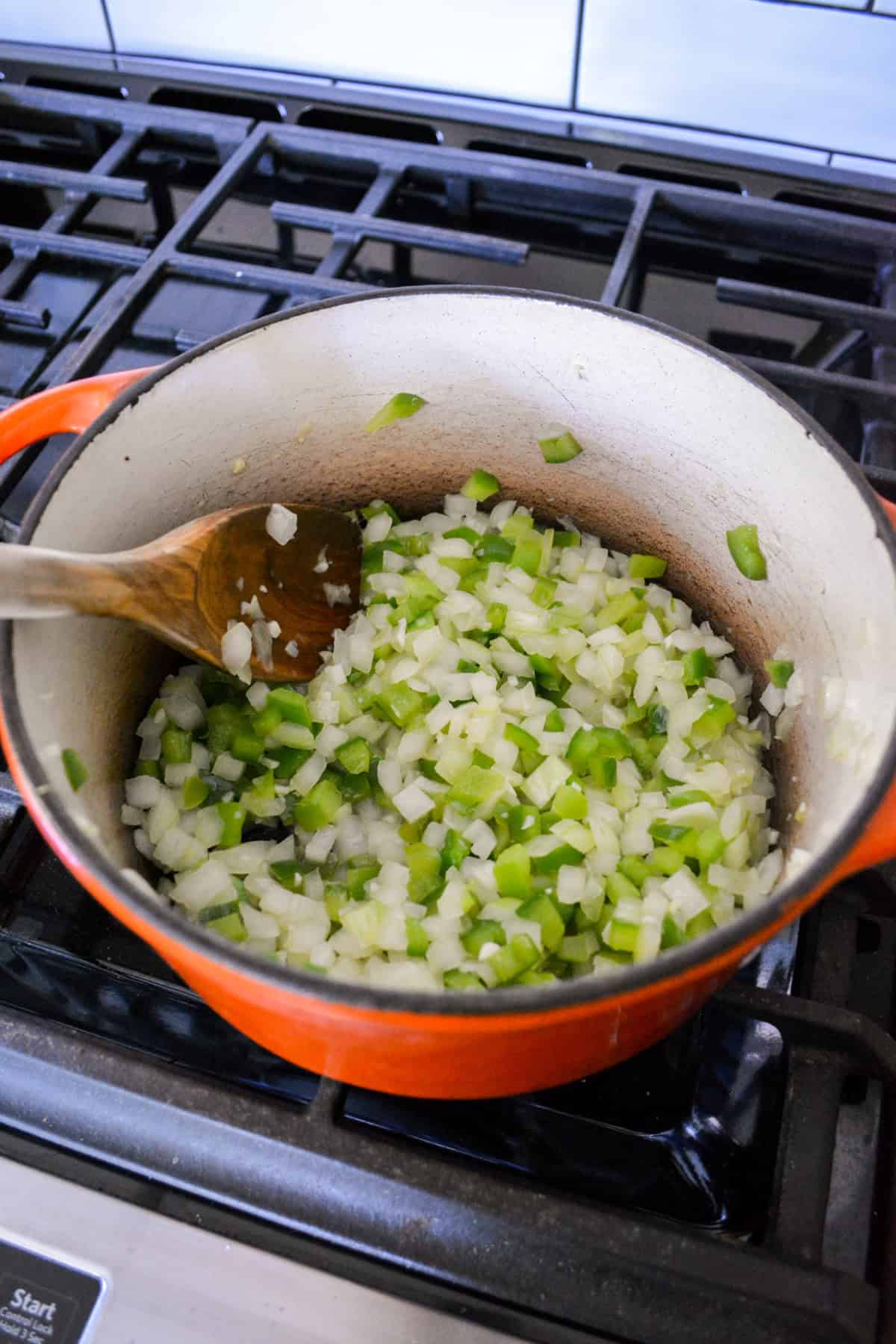 Pepper and onion cooking in a Dutch oven.