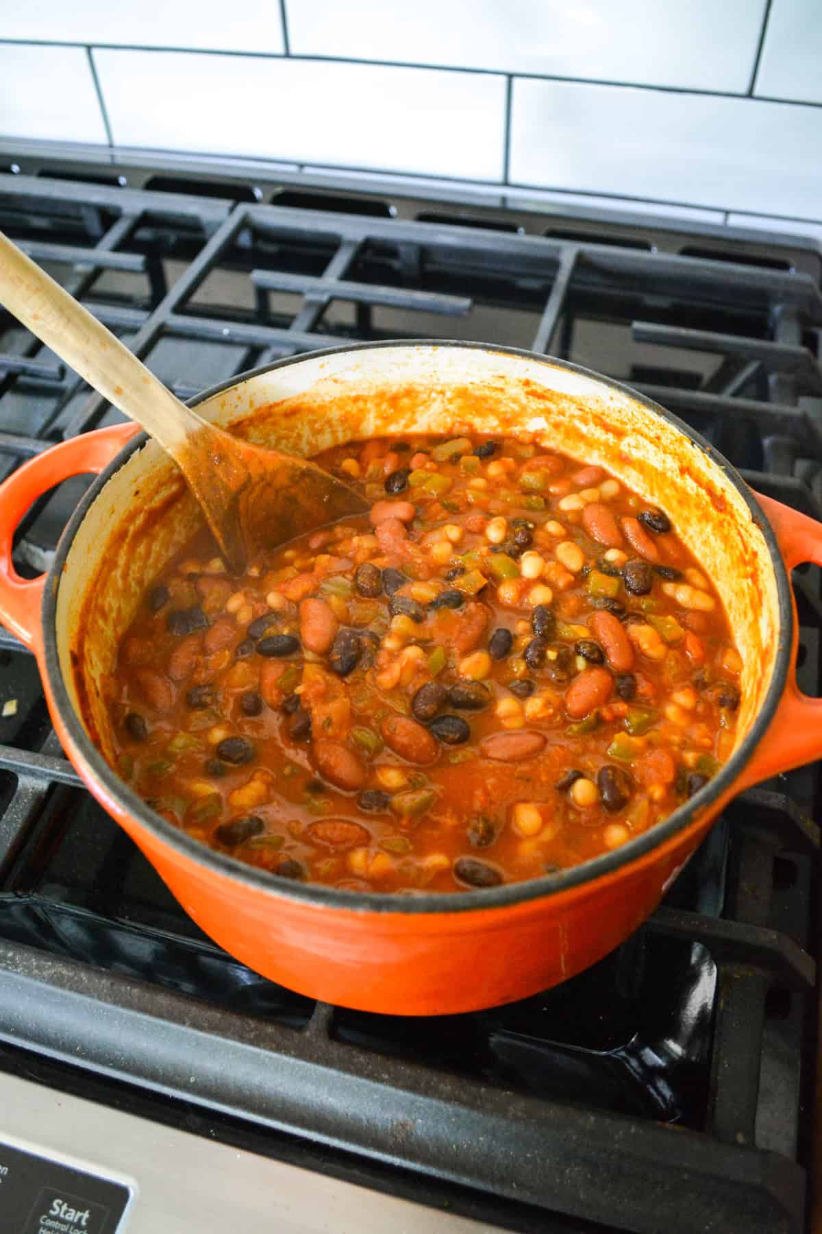 Finished chili in a Dutch-oven on a stove.
