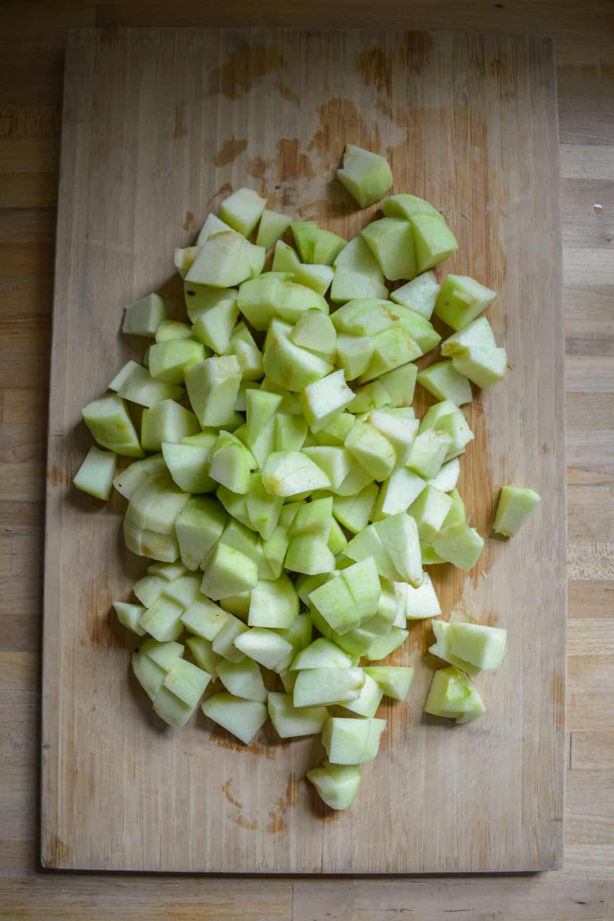 Diced apples on a wooden cutting board.