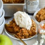 A small plate with Vegan Apple Crumble topped with ice cream.