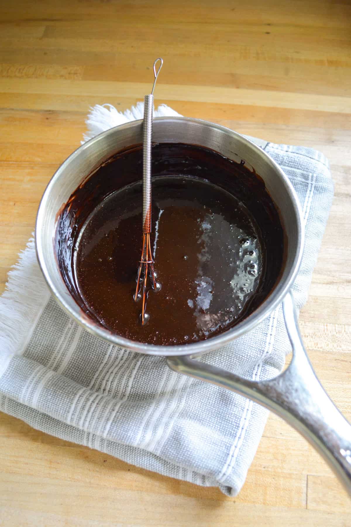 Vegan chocolate syrup in a saucepan.