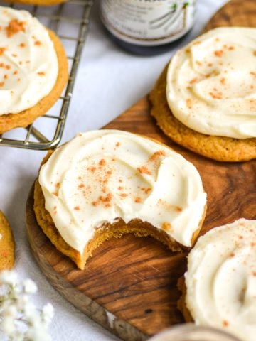 Vegan Iced Pumpkin Cookies on a wooden board.