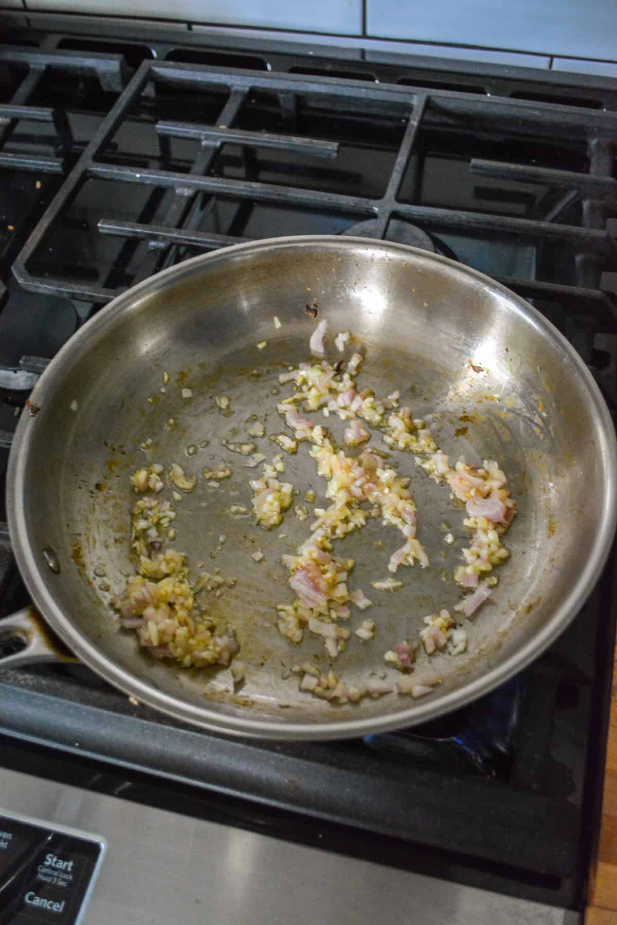 Sautéed shallot and garlic in a skillet.