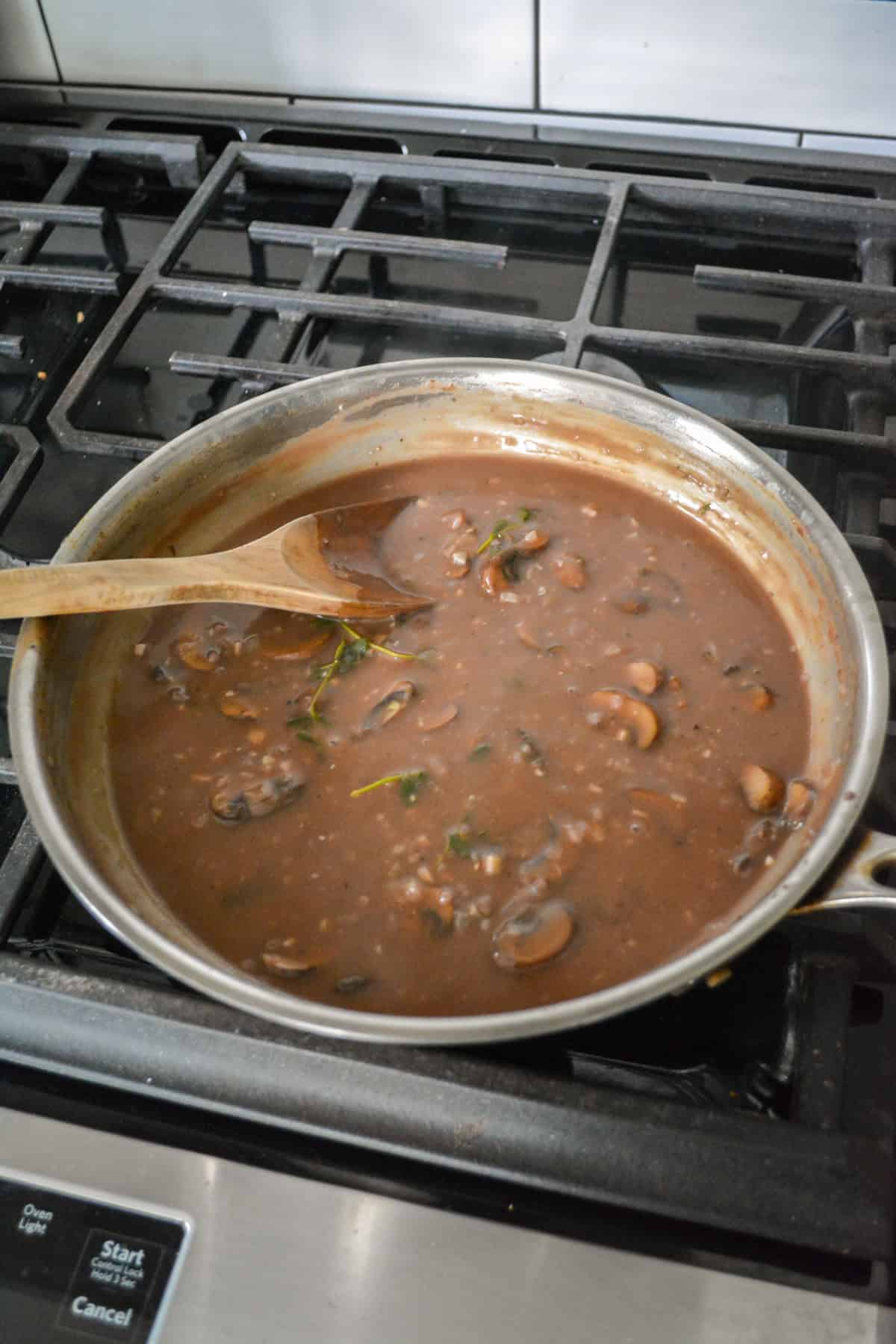 Gravy simmering in a skillet on the stovetop.