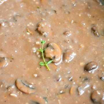 Vegan Mushroom Gravy topped with a sprig of thyme.