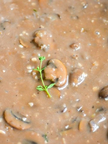 Vegan Mushroom Gravy topped with a sprig of thyme.