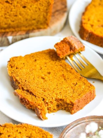 Vegan pumpkin bread on a plate with a fork.