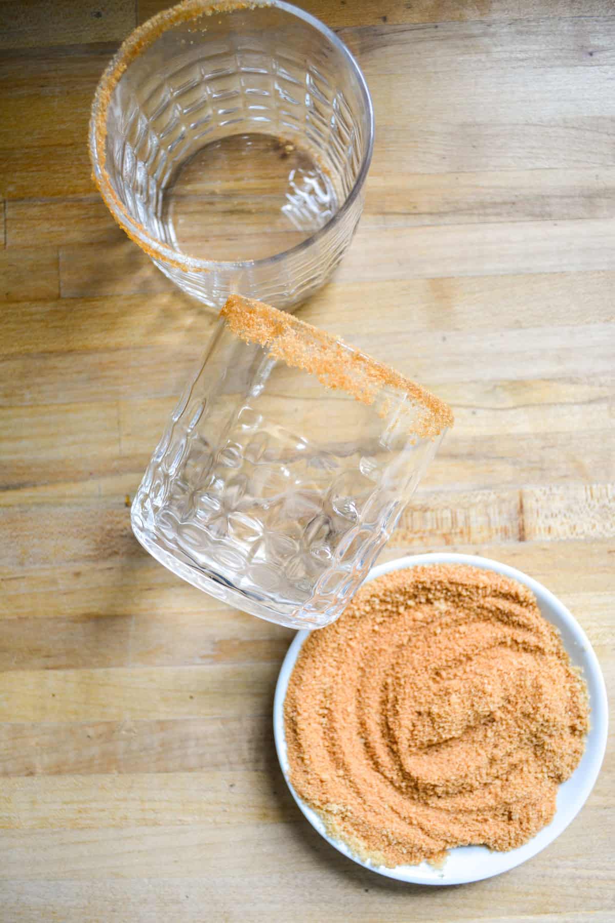 A glass with its rim dipped in brown sugar and cinnamon.