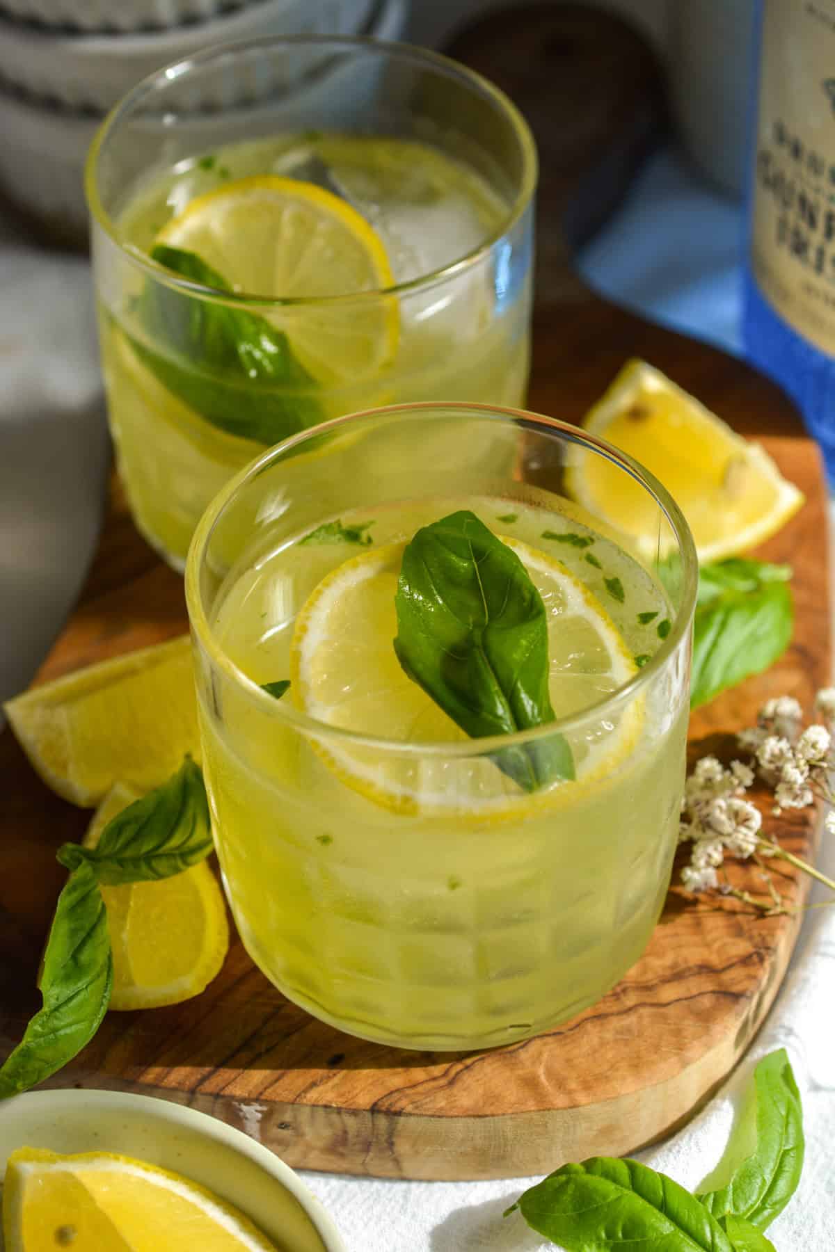 Gin Basil Smash in a glass on a wooden board.