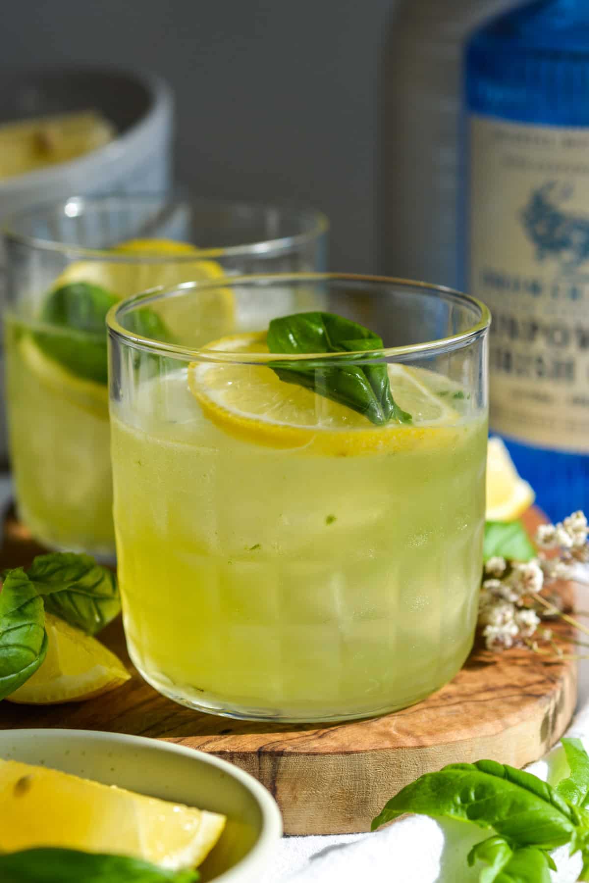 Gin Basil Smash in a glass on a wooden board.