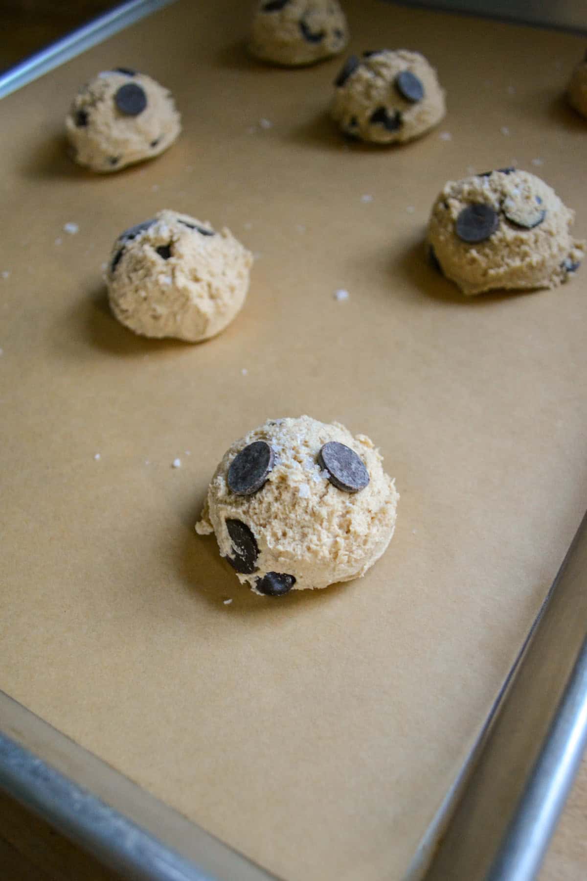 Cookies scooped onto a parchment lined baking sheet.
