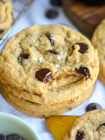 A Gluten Free Vegan Chocolate chip Cookie with a bite taken out of it.