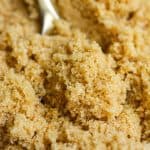 Homemade light brown sugar on a gold spoon.