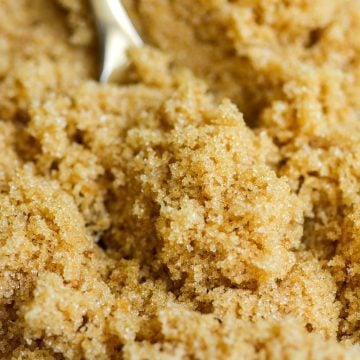 Homemade light brown sugar on a gold spoon.