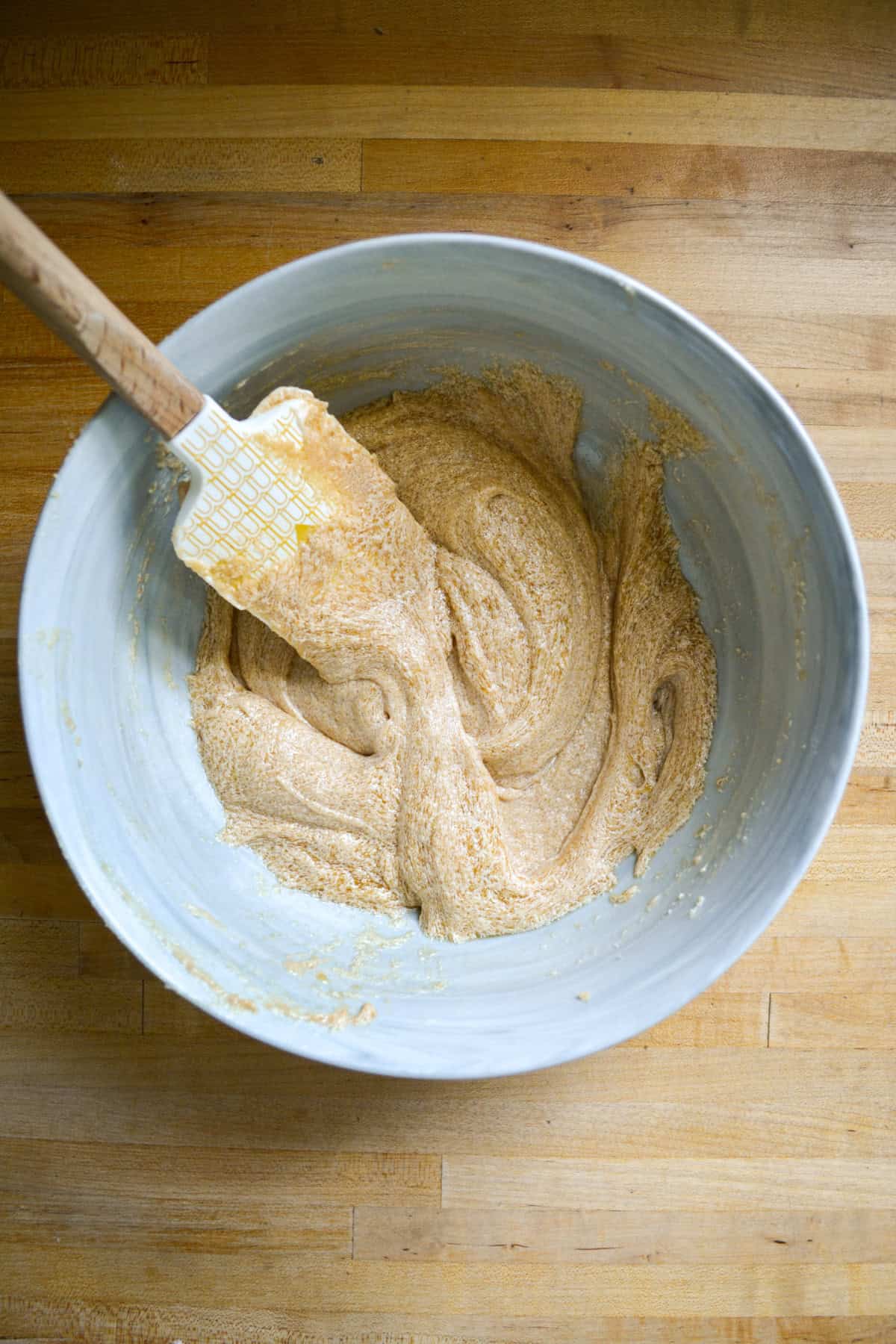 Non-dairy milk and vanilla mixed into the creamed butter mixture in a large bowl.