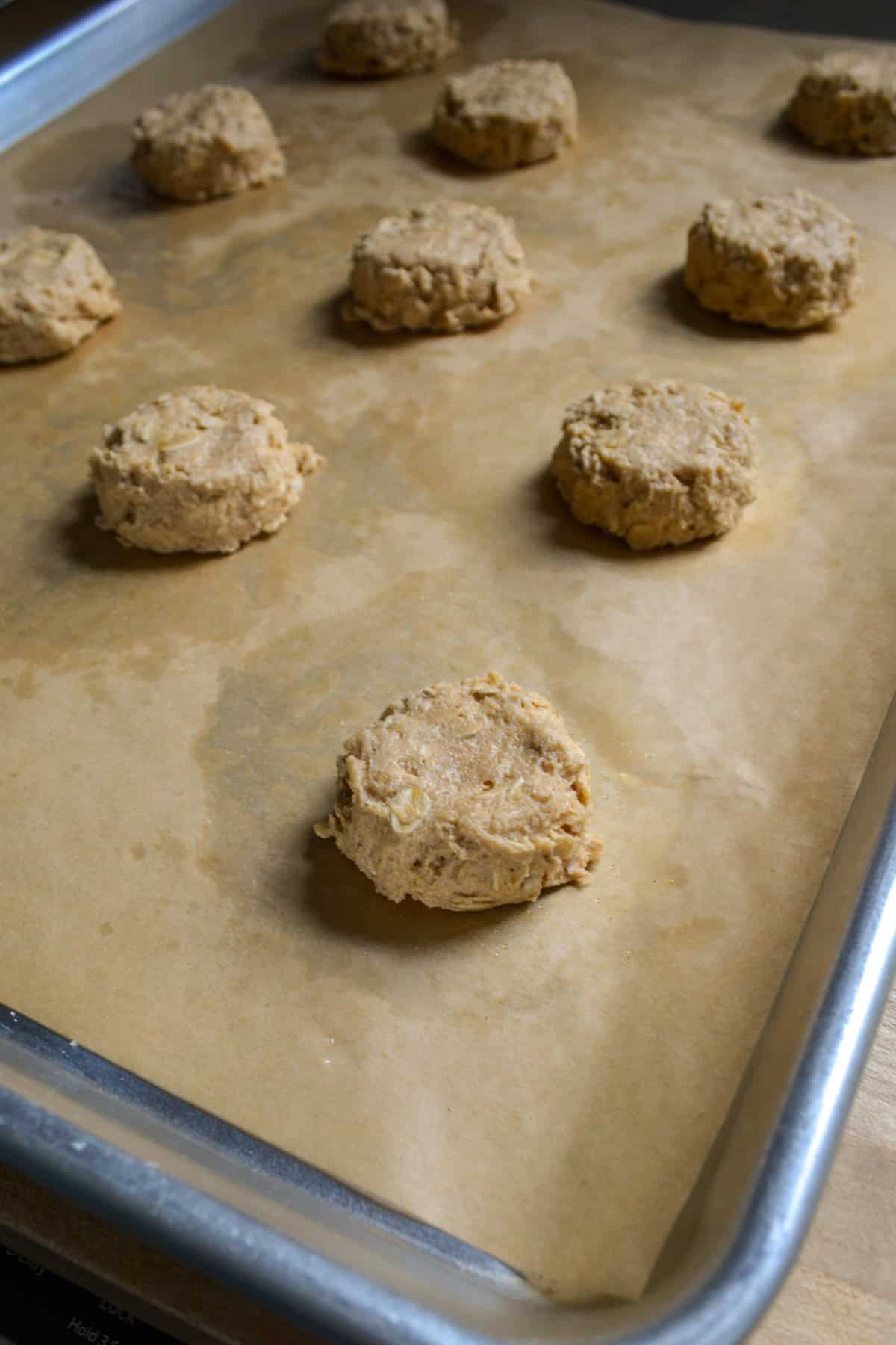 Cookie dough scooped onto a lined baking sheet.