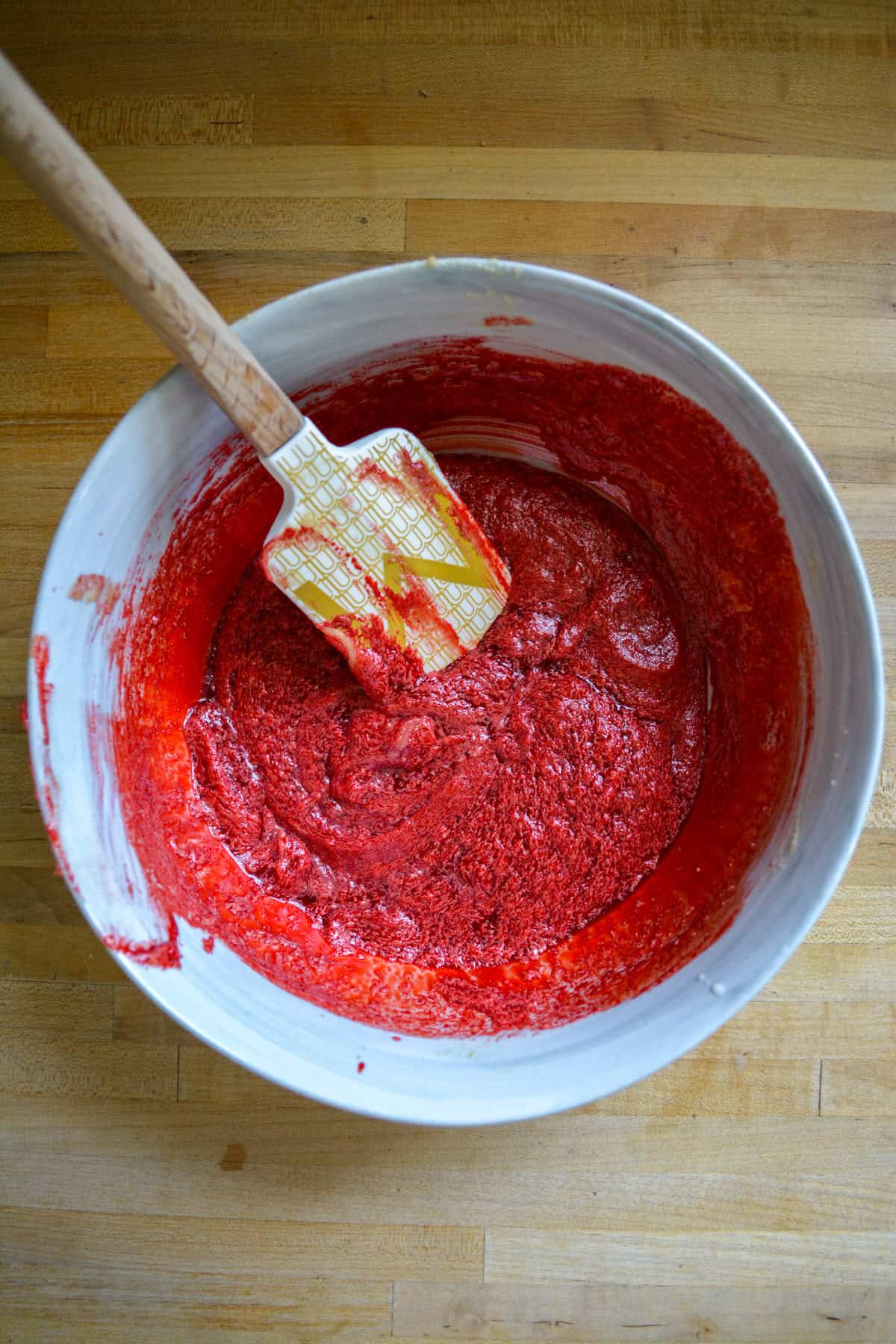 Red food coloring added to the mixture in a large bowl.