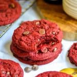 A stack of Vegan Red Velvet Chocolate Chip cookies on a linen cloth.
