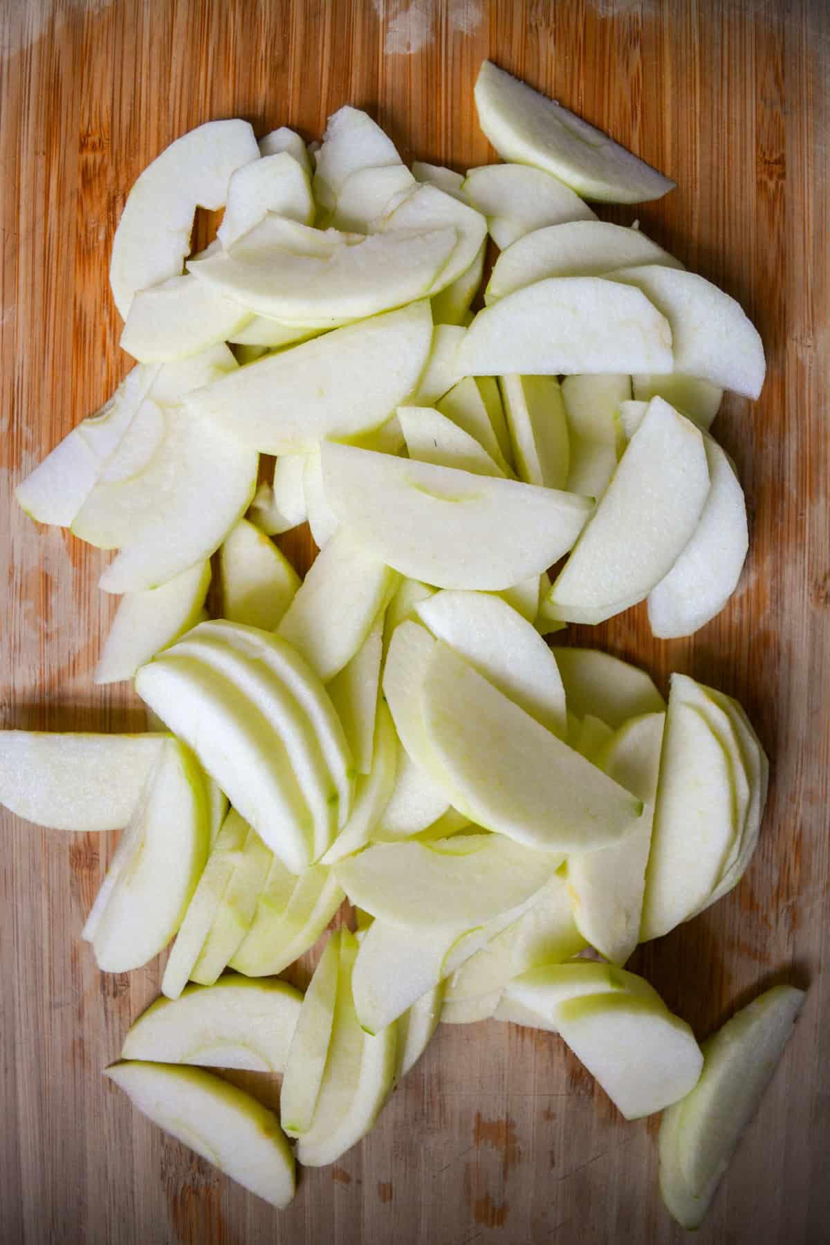 Sliced apples on a wooden cutting board.