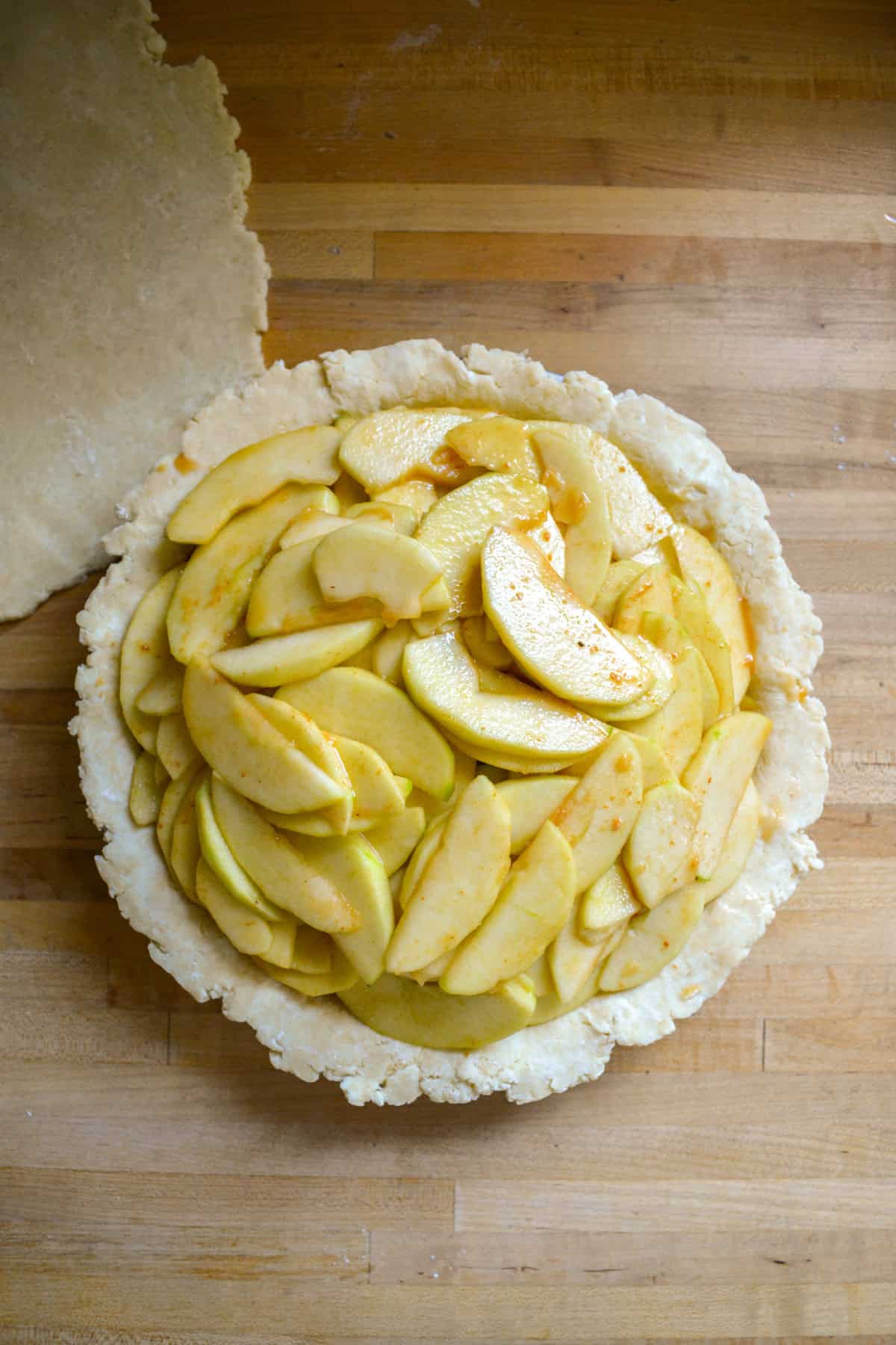 Apples piled into the pie plate.