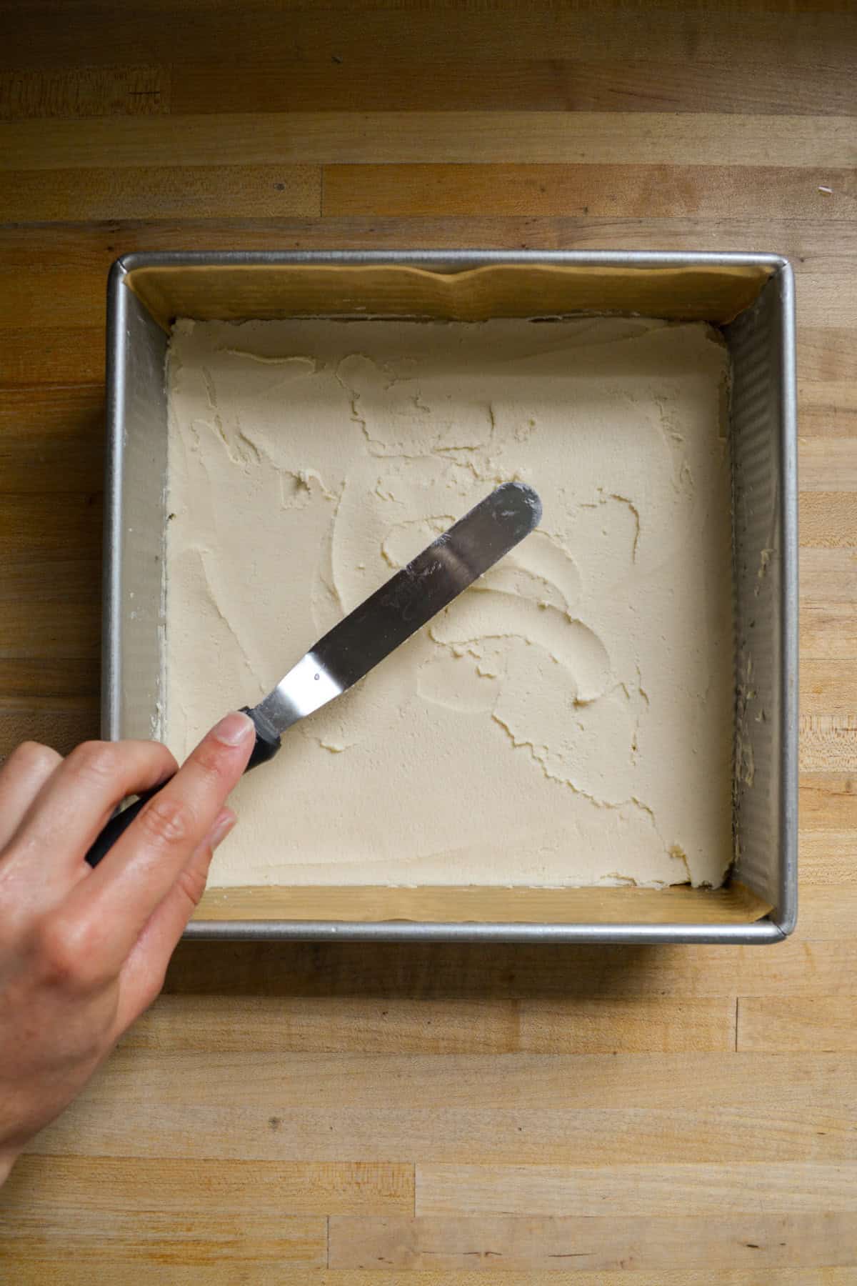 Shortbread crust pressed into a square baking pan.