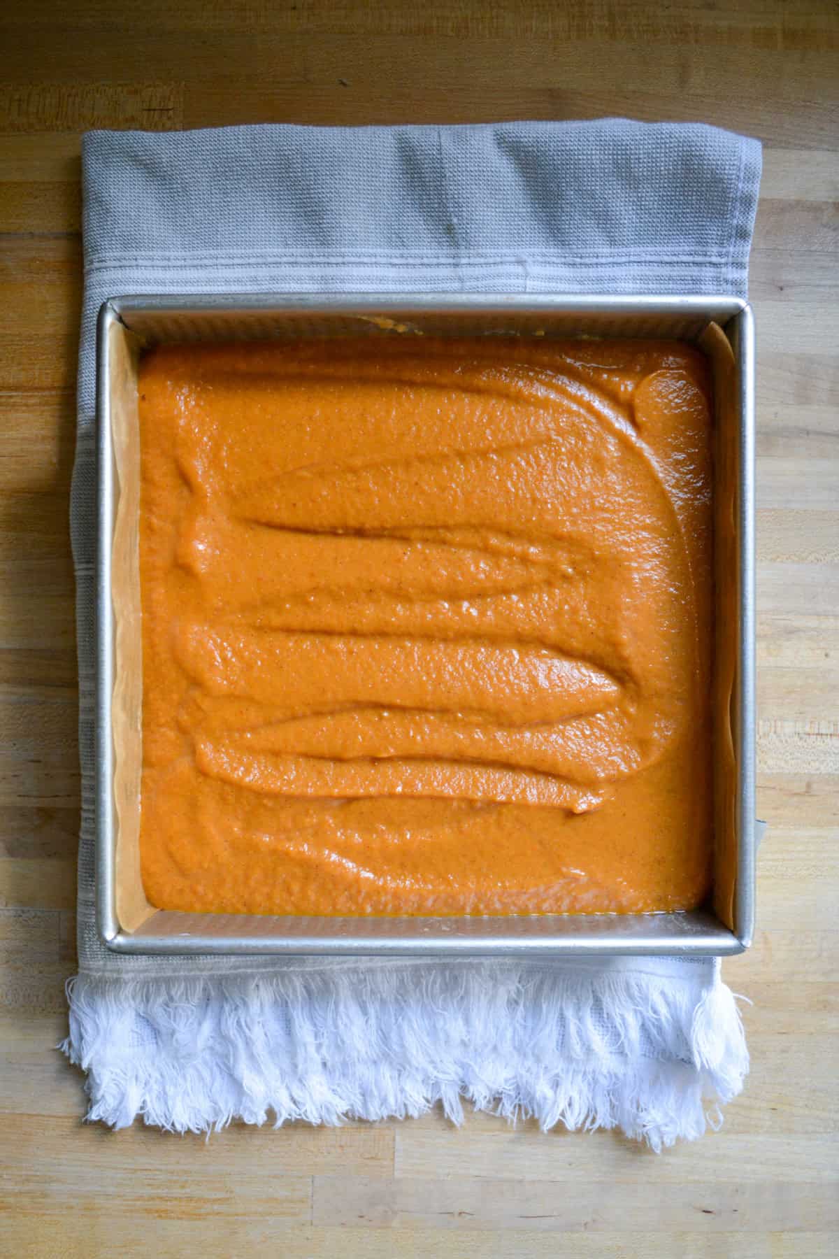 Pumpkin filling poured into the baking pan.