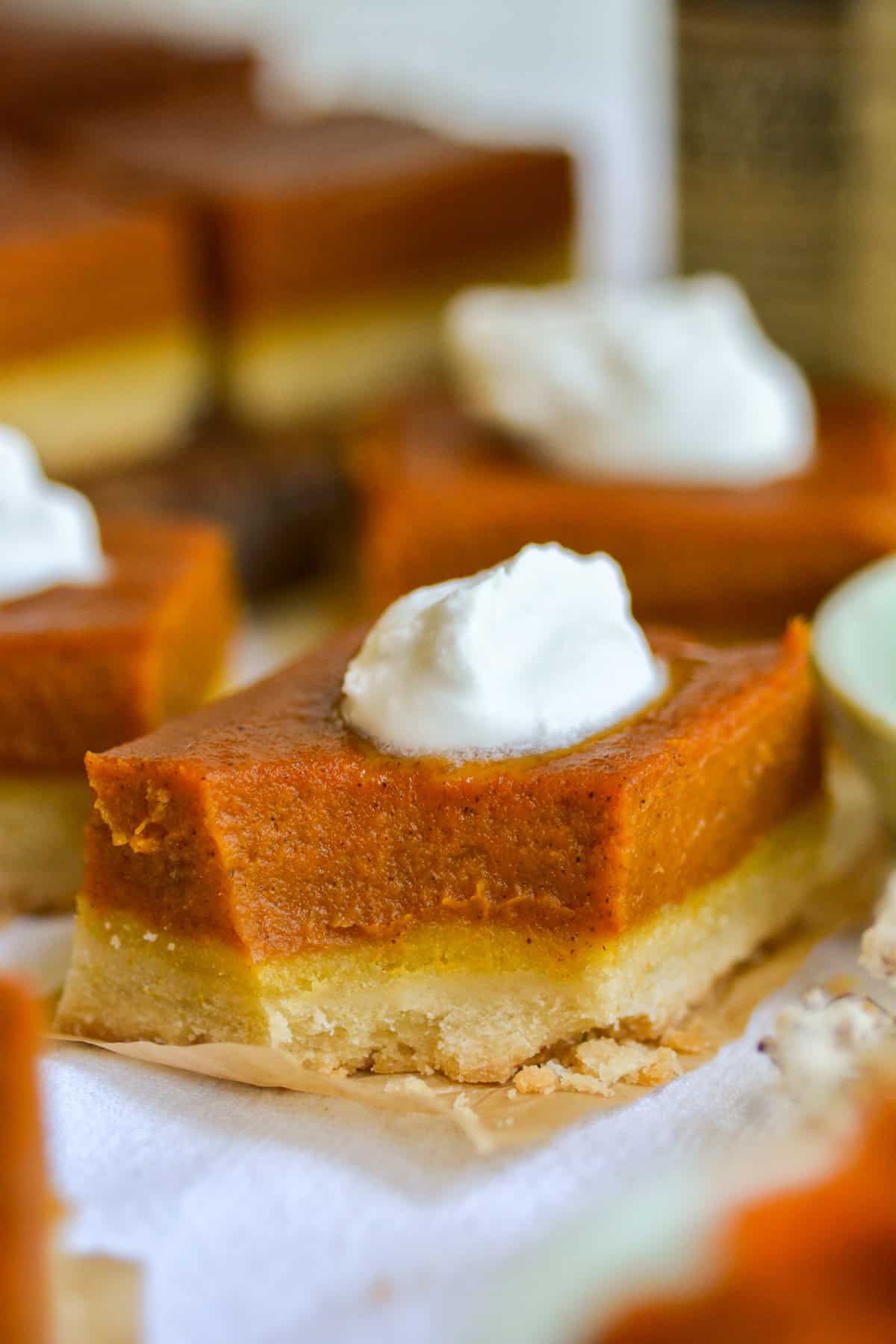 A vegan pumpkin pie bar with a bite taken out of it on a linen cloth.