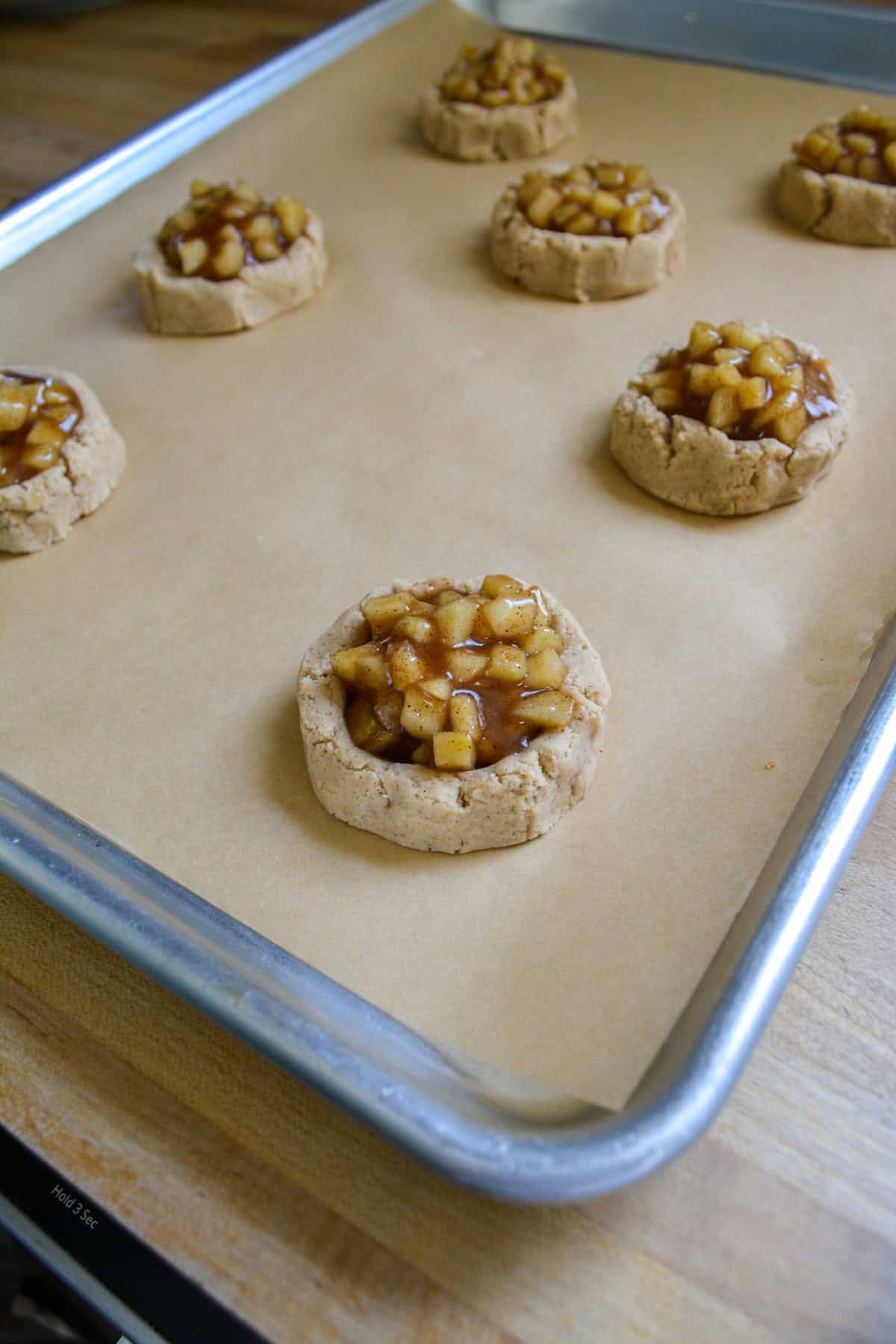 Cookie dough filled with apple pie filling ready to be baked.